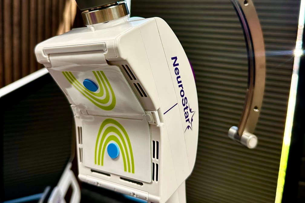 Close view of the NeuroStar treatment coil above the chair's headrest.